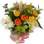 Vibrant display of seasonal flowers with liliums, roses, orange germinis, solida...