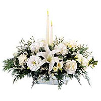 White flowers with 2 white taper candles and holiday greens are a beautiful deco...