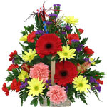 A colourful flower arrangement in a dish/in a basket. ...