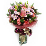 A round bouquet in pink, made from lilies, carnations, chrysanthemums, and vario...