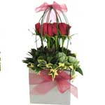 Eye catching box of roses surrounded with interesting greenery and chiffon ribbo...