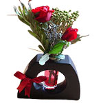 Simply charming, this arrangement of three roses is placed in a glass vase. The ...
