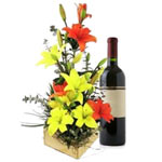 Beautiful arrangement of lilies with a Casillero del Diablo bottle of wine (750m...