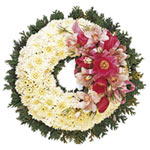 A striking memorial wreath including delicate chrysanthemums and cymbidium orchi...