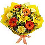 This lovely assortment of orange and yellow flowers, including lilies, gerbera d...