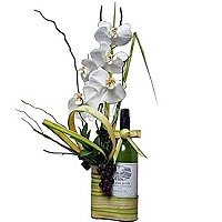 Classic flowers arrangement by white orchid phalaenopsis, greenery and bottle of...