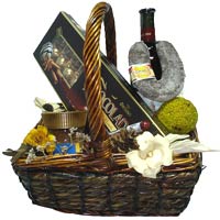 Basket with a bottle of red wine, sausage and inst...