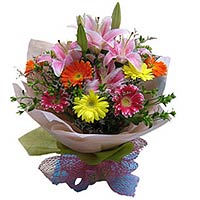 2 pink perfume lilies, 10 mixed color gerberas and greens, light pink round pack...