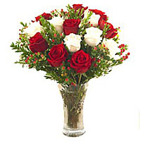 16 long stem roses vase arrangement in the holiday colors of red and white are a...
