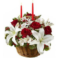 New Year composition with two candles in a basket with red roses, hypericum, lil...
