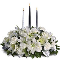 White roses with white lilies with three candles in a stunning silver compositio...