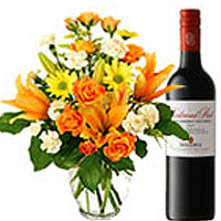 Exclusive Arrangement of Fresh Seasonal Flowers with 1 Bottle of Red Wine.