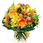Round bouquet of varied flowers, mostly yellow and orange....