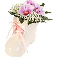 Sweet cream baby shoes with flower decoration. The decoration is made of orchids...