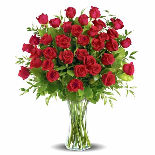 Three dozen long stemmed roses, arranged in a glass vase.
