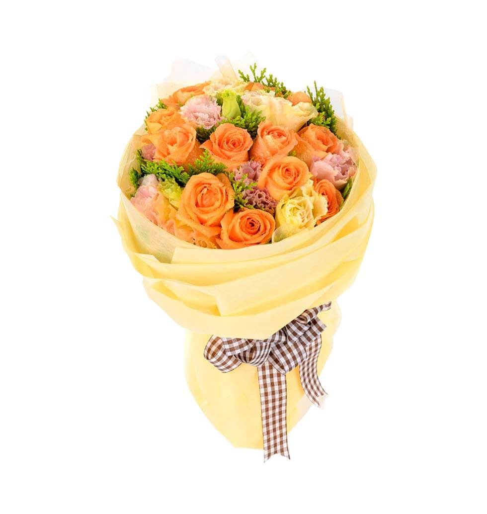 The soft colours of orange roses and assorted flow...
