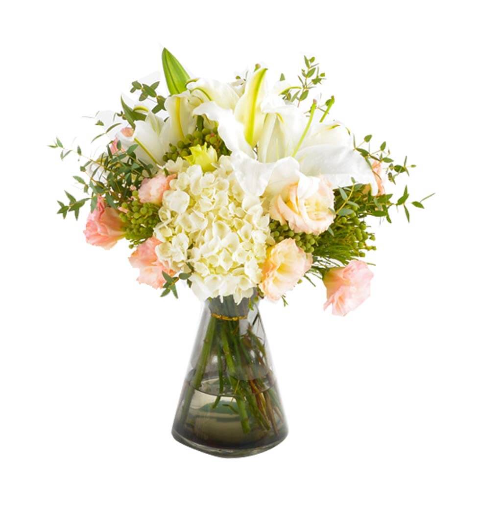 The lilies, hydrangeas, and eustomas in the vase g...