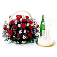A basket arrangement with birthday cake and champagne
