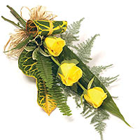 Bouquet of three yellow roses and green. Yellow color of the flowers is said to ...