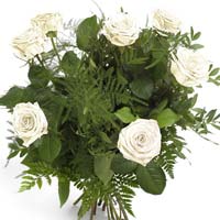 Bouquet of seven white roses and green. White color of the flowers is said to co...