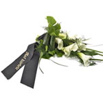 A subtle yet elegant mourning bouquet with glossy green leaves and white calla l...