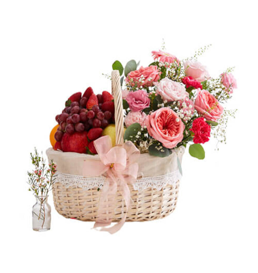 Fresh fruits and pink flowers in a wooden basket m...