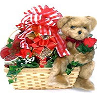 A lovable teddy bear sitting in a willow gift bask...