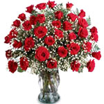 Three dozen long stemmed roses, arranged in a glas...