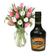 Bouquet of beautiful mixed colour seasonal flowers and cream liqueur Baileys ...